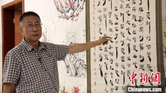 圖為朱群和他的敦煌漢簡(jiǎn)書(shū)體?！「攥?攝