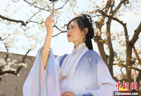 圖為蘭州青年身穿漢服在百年梨園賞景?！「哒?攝