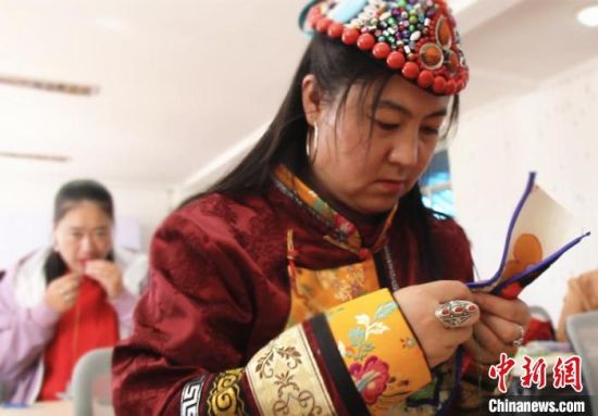 圖為裕固族婦女學(xué)習(xí)刺繡?！∈缝o靜 攝