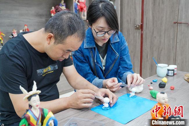 <a target='_blank'  data-cke-saved- >中新社</a>記者(右)現(xiàn)場體驗面塑制作過程。　陳爭強 攝