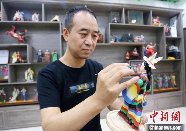 圖為安秋平正在創(chuàng)作代表隴南文縣民俗的《白馬人》作品。　高展 攝