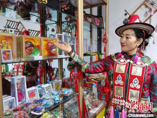 圖為身著民族服飾的隴原巧手展示手工藝品。(資料圖) 徐雪 攝