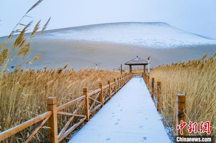 2021年11月28日，在敦煌鳴沙山月牙泉景區(qū)，沙雪交融，更顯北國風(fēng)情?！⊥醣筱y 攝