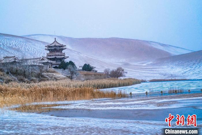 2021年11月28日，雪落鳴沙山月牙泉景區(qū)。　王斌銀 攝