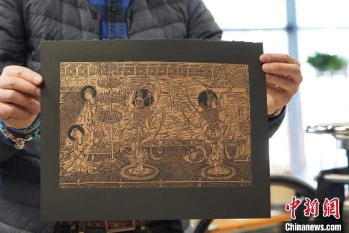 圖為手工書藝人展示敦煌雕版壁畫印刷品?！【琶赖┰?　攝