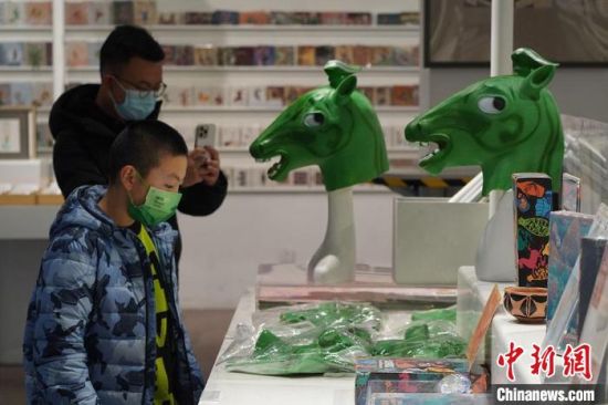 圖為“神馬來了”銅奔馬頭套吸引參觀者駐足?！【琶赖┰?攝