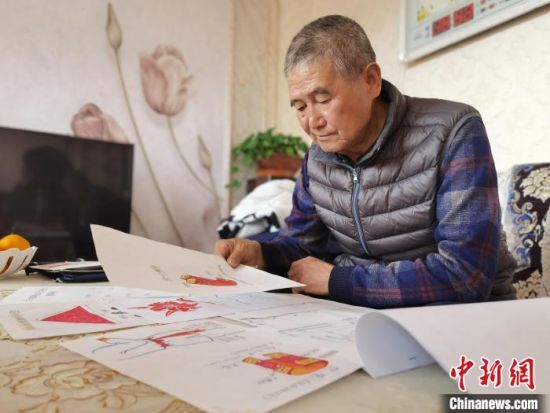 圖為陸鵬飛向記者展示多年帶隊(duì)的手寫筆記?！堟?攝