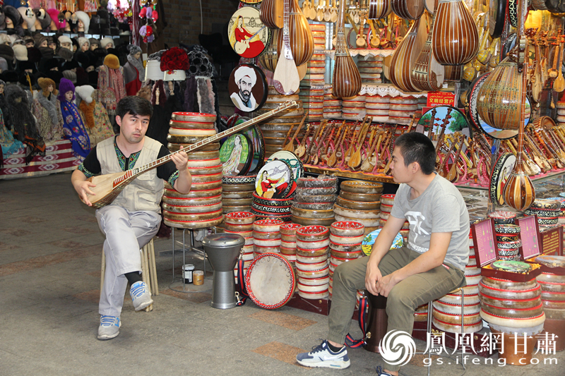 烏魯木齊二道橋巴扎內(nèi)，店主正在向客人展示樂器。楊文遠(yuǎn) 攝