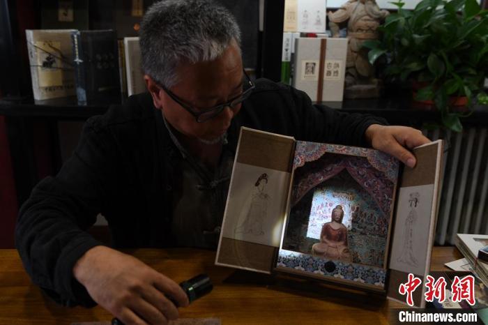 圖為讀者出版集團讀者晉林工作室獨立出品人徐晉林，展示互動性強的敦煌題材手工書。(資料圖) 楊艷敏 攝