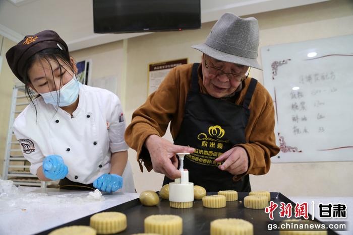 當(dāng)日，受邀參加活動(dòng)的臺(tái)胞臺(tái)屬代表、兩岸婚姻及子女、在甘臺(tái)商代表等歡聚一堂。圖為77歲的在甘臺(tái)胞潘天鑒制作月餅。九美旦增 攝
