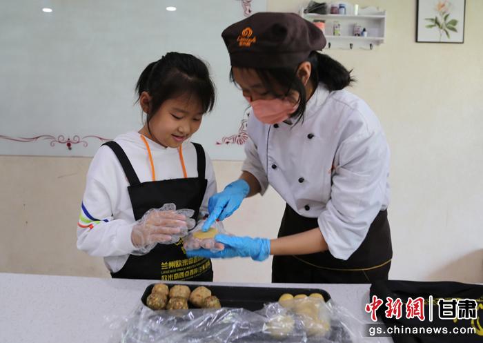 圖為在甘臺(tái)胞小朋友在工作人員指導(dǎo)下制作月餅。九美旦增 攝