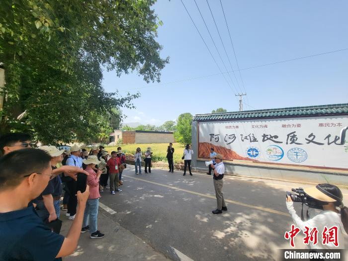 圖為中國(guó)地質(zhì)大學(xué)(北京)教授張緒教介紹村落情況?！『衍?攝