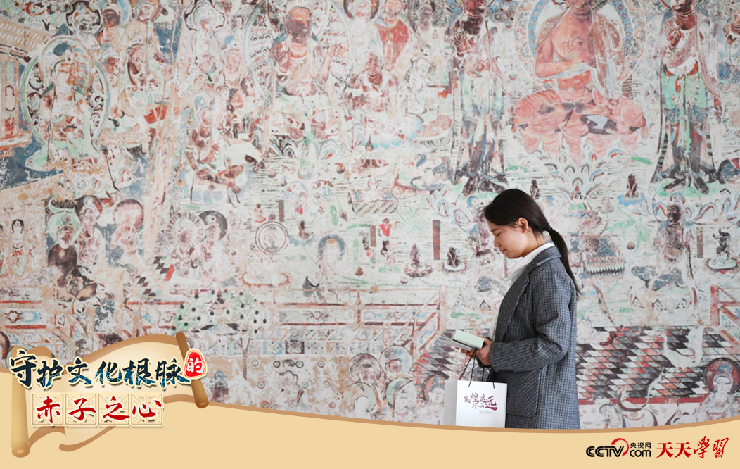 2023年4月25日，敦煌研究院文物數(shù)字化保護(hù)團(tuán)隊(duì)創(chuàng)意營銷人員廖雪婷從一幅高保真復(fù)制壁畫前走過。