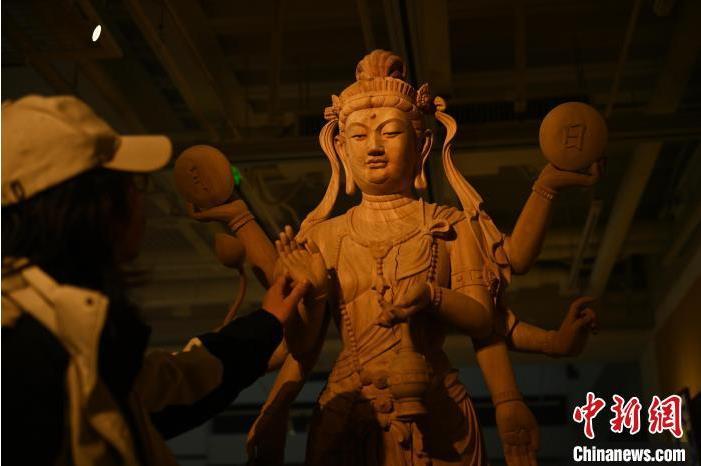 圖為季茂杰觀察自己創(chuàng)作的敦煌木雕。李亞龍 攝</p>
<p>