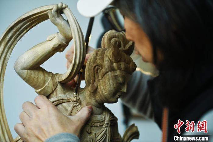 圖為季茂杰進(jìn)行敦煌元素的木雕創(chuàng)作。李亞龍 攝</p>
<p>