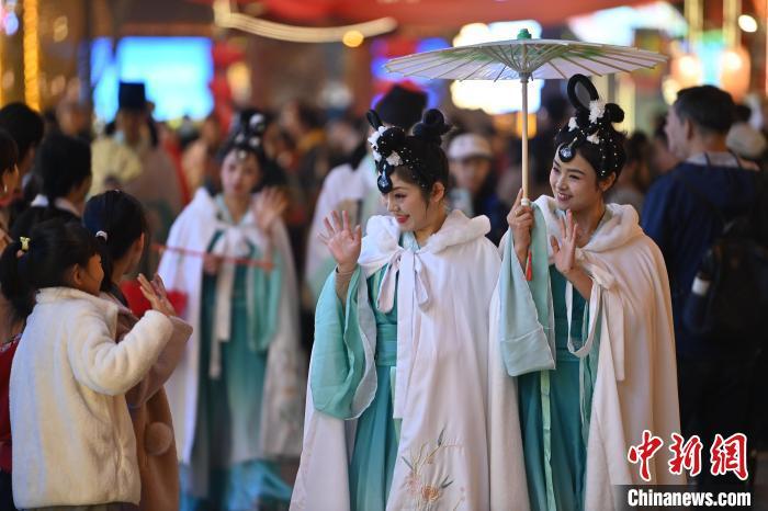 圖為街區(qū)人員著傳統(tǒng)服飾與游人互動(dòng)。李亞龍 攝</p><p>