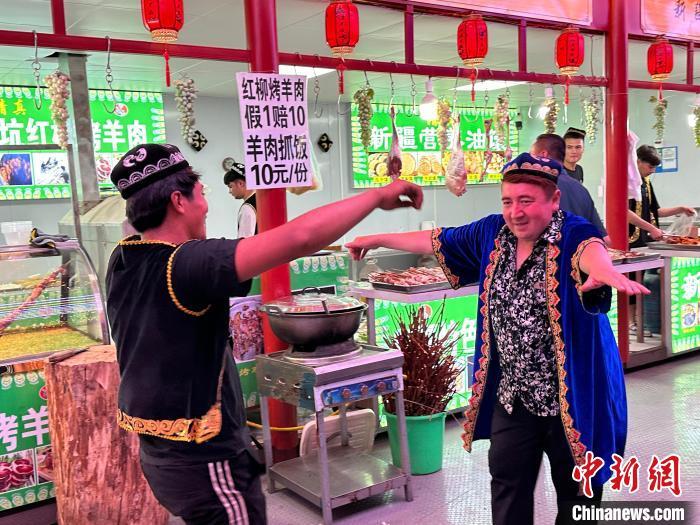 圖為餐飲經(jīng)營(yíng)者在“西涼不夜城”跳起舞蹈引客?！〈魑牟?攝</p><p>