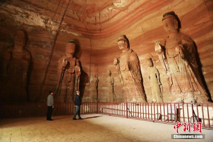 7月15日，游人參觀甘肅省平?jīng)鍪袥艽h百里石窟長廊中的南石窟寺1號窟。百里石窟長廊位于涇川縣境內(nèi)，由512個(gè)石窟、5眼窟中石井組成，現(xiàn)存王母宮石窟、鳳凰山石窟、南石窟寺、丈八寺石窟、羅漢洞石窟、太山寺石窟等規(guī)模較大的石窟群，還有數(shù)量眾多的小石窟群。南石窟寺開鑿于北魏永平三年，其中1號窟屬于大型七佛窟，七佛高達(dá)6米。中新社記者 李亞龍 攝